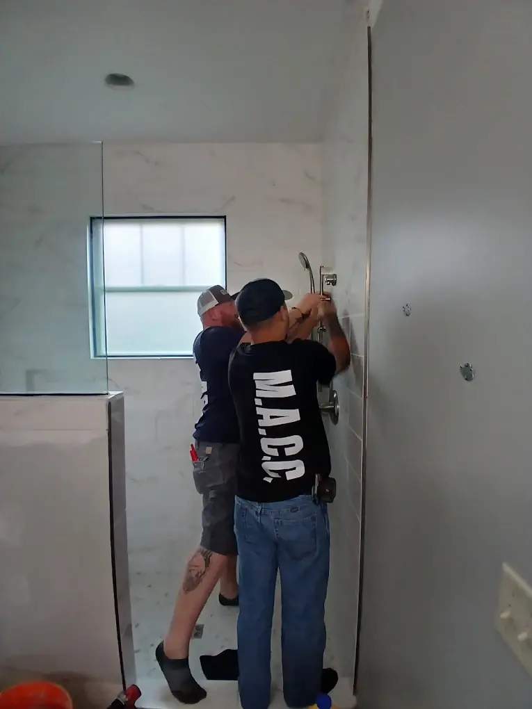 Two MACC plumbers installing a shower fixture
